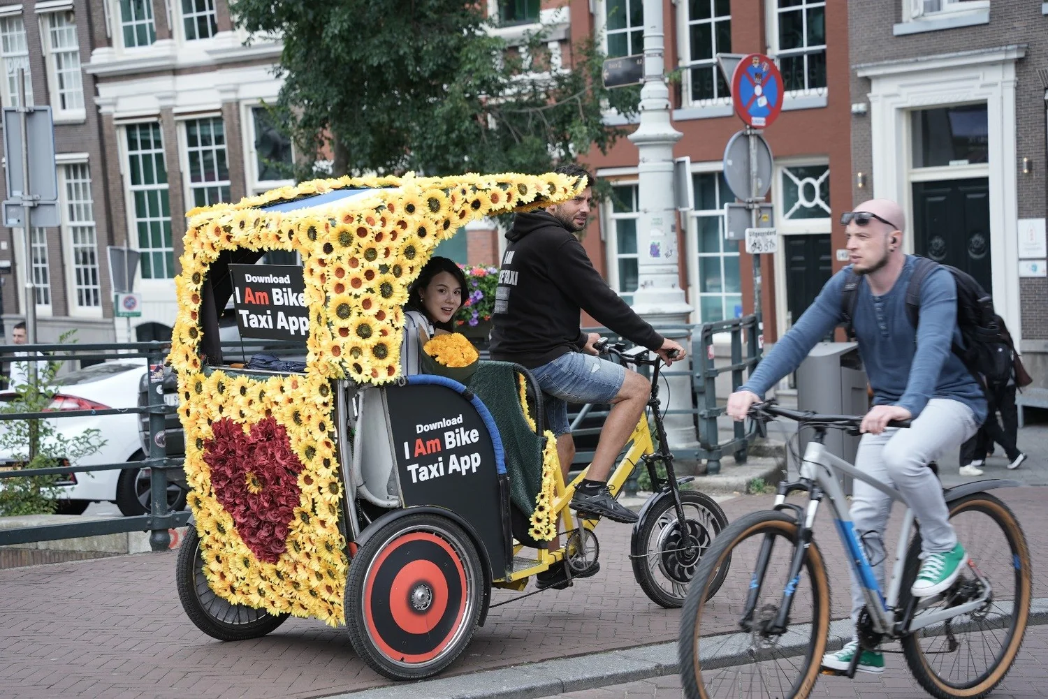 Local driver taking passengers through Amsterdam by rickshaw